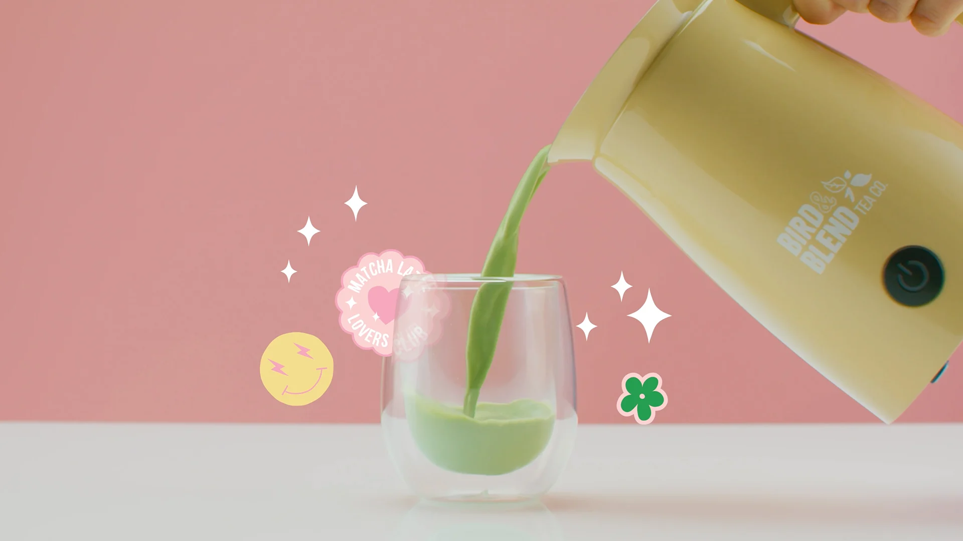 Matcha poured from the yellow Magic Whisk into a glass, surrounded by animated flowers and sparkles.